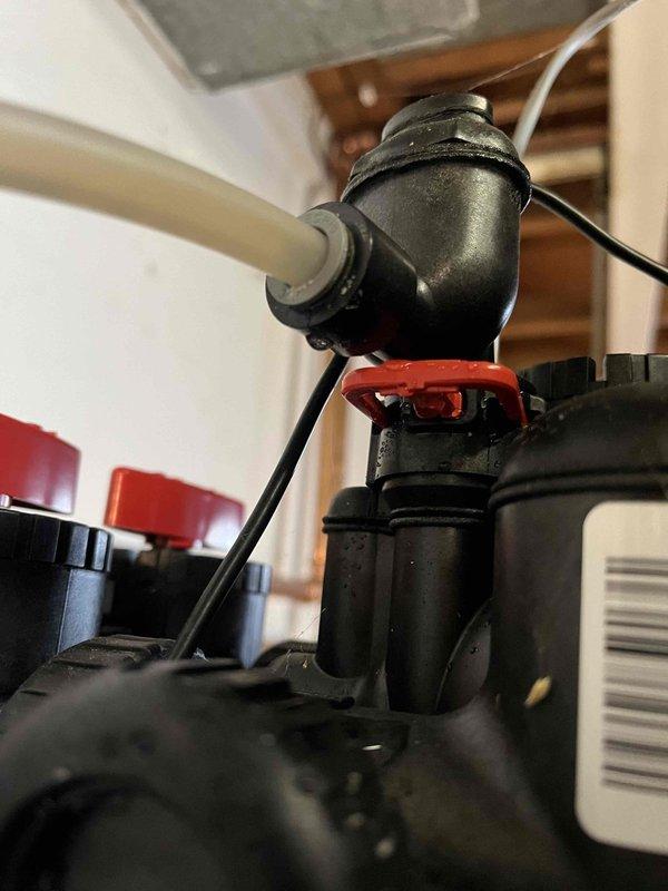 Inspected water softener system that was leaking onto floor with salt solidification issues. Identified and replaced faulty black valve assembly with damaged red gasket at connection point. Verified proper operation after repair and confirmed system is now functioning correctly on dedicated electrical circuit.