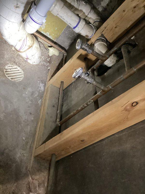 Conducted a consultation for multiple plumbing projects including conversion from a 50-gallon electric water heater to a tankless system, replacement of well pump pressure tank, and reconfiguration of laundry supply lines. Visual inspection revealed existing water heater installation with copper supply lines against concrete block wall in utility area, and separate plumbing installation with PVC pipes requiring modification for laundry appliance repositioning. Provided comprehensive quotes for all requested services.