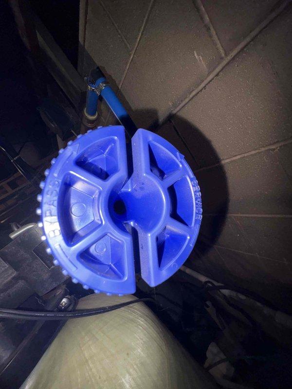 Diagnosed low water pressure issue by inspecting pressure gauges in the main supply line showing readings below normal parameters. Identified clogged filtration system as the source of restriction; performed maintenance on the blue circular filter assembly including a complete flush cycle to remove sediment buildup. Restored system pressure to optimal levels as verified by post-service gauge readings.