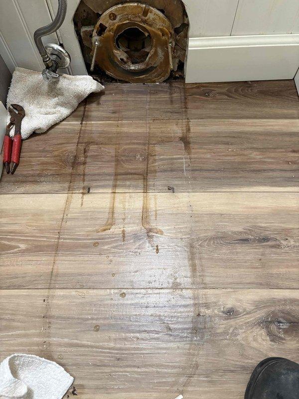 Replaced deteriorated wax ring on rear outlet toilet which had failed, causing significant water leakage. Inspection revealed water damage to surrounding flooring and corrosion at the toilet flange. Completed removal of old seal, cleaned mounting surface, and installed new seal to prevent further leakage.