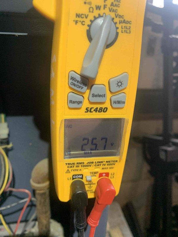 Performed boiler maintenance service visit. Conducted voltage testing with Fieldpiece SC480 multimeter, measuring 25.7 volts. Identified significant dust and debris accumulation throughout system components, with visible surface corrosion and deterioration of metal structures requiring attention.