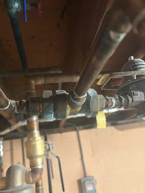 Repaired leaking pipe on aging boiler system. Inspection revealed compromised connection at pipe junction with hex nuts. System operating at approximately 80-90°F with pressure reading 20-30 PSI after service completion.