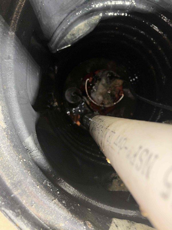 Replaced malfunctioning sump pump with new 65W model that was leaking at discharge connection. Inspected basin interior, found debris and residue causing improper sealing. Cleaned basin, reseated discharge pipe, and confirmed proper operation with no further water leakage.