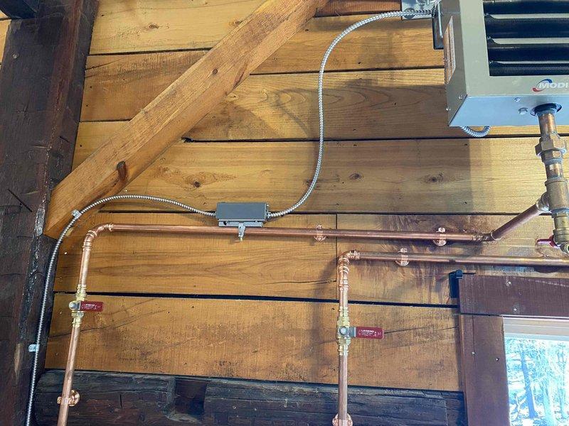 Returned to complete installation job originally sold by sales representative. Installed copper piping along wooden wall structure with appropriate T-joints and shut-off valves, connecting to existing HVAC equipment. Also installed toilet in bathroom corner, properly secured and functional.