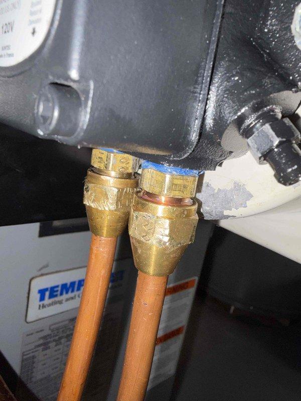 Inspected oil furnace system to address reported oil leak following previous pump replacement. Examined copper line connections at the Tempstar unit, focusing on brass compression fittings where leakage was suspected. Visual inspection revealed minor residue around fittings, which were tightened to resolve the issue.
