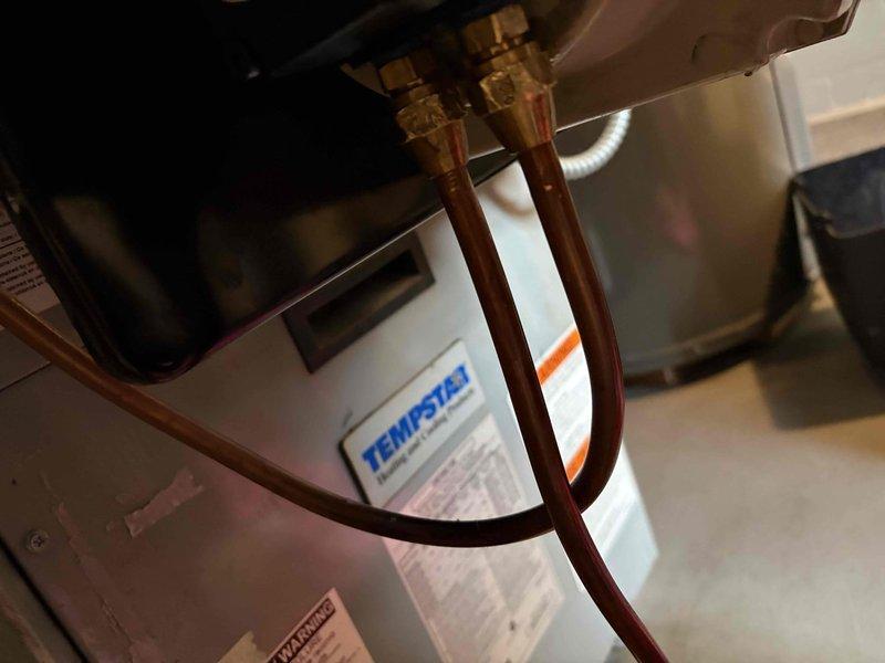 Inspected oil furnace system to address reported oil leak following previous pump replacement. Examined copper line connections at the Tempstar unit, focusing on brass compression fittings where leakage was suspected. Visual inspection revealed minor residue around fittings, which were tightened to resolve the issue.