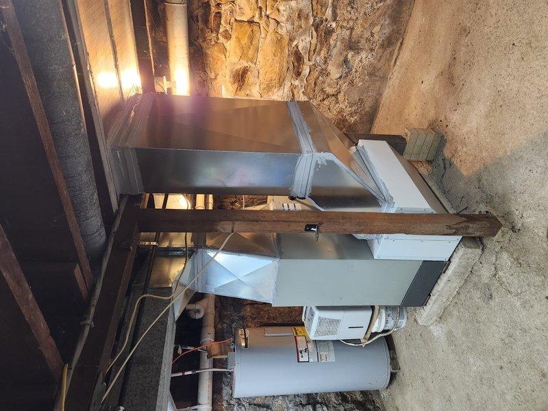Successfully completed installation of a complete HVAC system in residential basement, including new air handler with connected ductwork and associated components. System was properly integrated with existing water heater and utility connections, with all electrical wiring secured according to code requirements. Final inspection confirmed proper operation of all installed equipment.