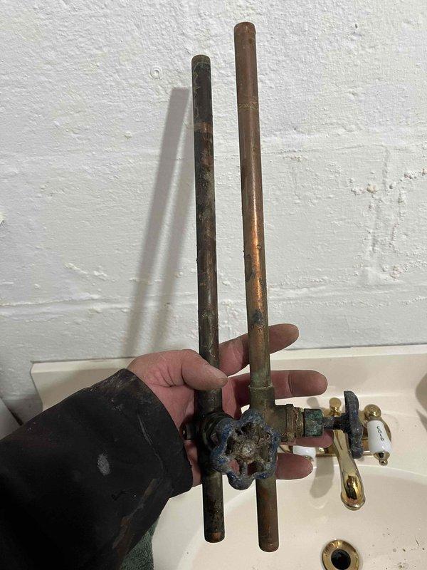 Replaced leaking hot and cold shut-off valves in basement that supplied bathroom fixtures. Removed corroded copper pipes and valve assembly, installing new quarter-turn valves with proper brass fittings. Tested system for proper operation and verified no leaks at connection points.