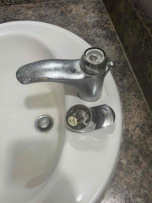 Diagnosed and repaired leaking bathroom faucet with chrome fixtures mounted on granite/marble countertop. Addressed mineral buildup and water spots on fixtures, restoring proper function and preventing further water damage.