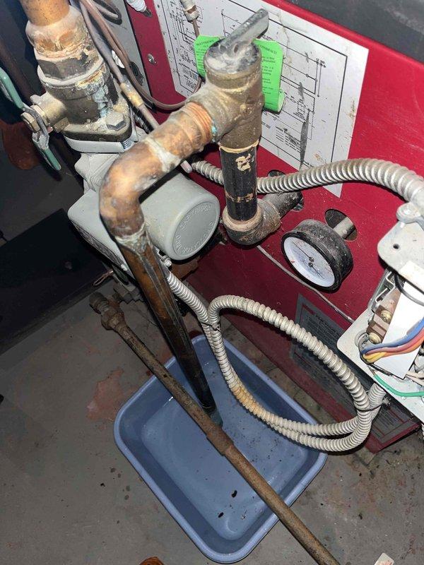 Responded to service call for non-functioning boiler system. Inspected aging copper piping installation which showed significant oxidation and corrosion. Identified and repaired a leak at the elbow joint where dampness and rust were present, and verified proper operation of the pilot light and pressure systems. System was restored to normal heating function.