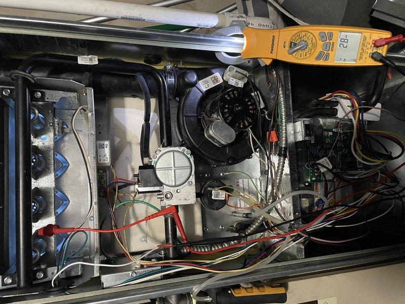 Responded to a callback for persistent system issue. Inspected interior HVAC components with access panel removed, using Fieldpiece multimeter which displayed a reading of 22. Discovered white plastic connector with significant contamination/residue buildup in connection ports that was likely causing system malfunction.