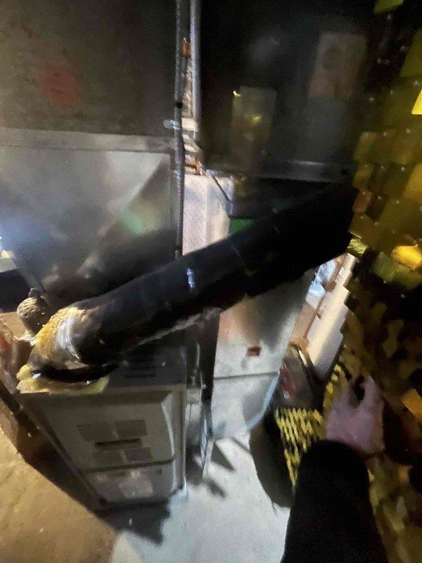 Inspected customer's existing HVAC system to evaluate feasibility of adding air conditioning. Examined 14-year-old furnace and thermostat wiring configuration (G,W,Y,Rh,Rc terminals with jumper). Documented basement mechanical area including existing ductwork and connections for potential AC integration.