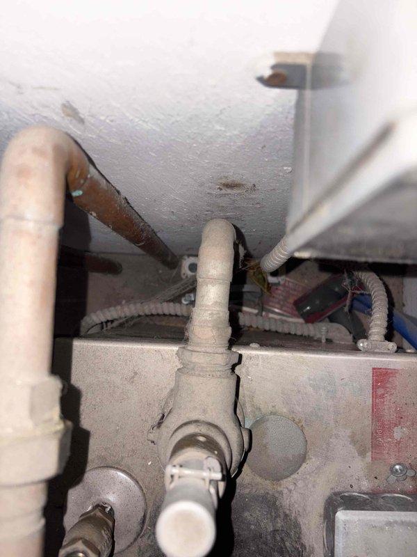 Conducted on-site assessment for replacement of outdated coal burner with new gas boiler system to power existing radiant floor heating. Evaluated current hydronic distribution system featuring four zone circulation pumps mounted on wooden backboard with associated copper piping, valves, and pressure gauges. Inspected connection points for proper integration with existing PVC piping and identified optimal location for new boiler installation while documenting current mechanical connections and electrical requirements.