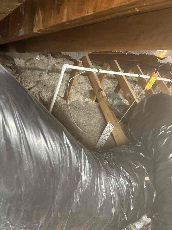 Returned to install condensate pump previously sold. Inspected HVAC ductwork in attic space confirming proper installation of flexible ducts with black insulation. Accessed crawlspace to install pump, verified connection to existing PVC drainage line running through floor joists, and confirmed proper operation with vapor barrier intact.