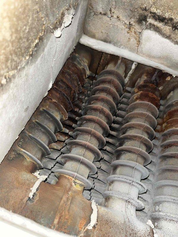 Responded to service call for boiler leaking from base. Upon inspection, discovered significant corrosion on heat exchanger coils with rust formation. Diagnosed failed gasket causing water leak. Documented extensive deterioration of internal components that will require replacement parts on follow-up visit.