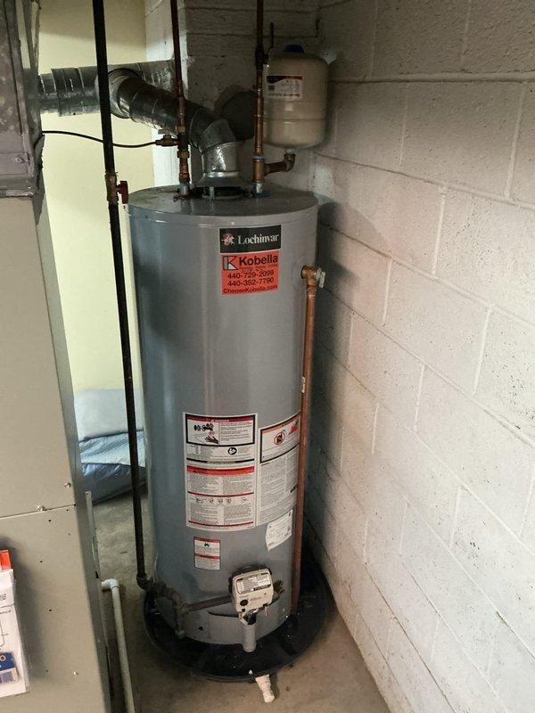 Conducted routine plumbing maintenance visit on water heating system featuring a Lochinvar unit with proper ventilation and expansion tank. Inspected basement piping infrastructure, noting wooden joists with some wear and multiple properly mounted supply lines. Customer requested quote for outdoor drainage issue to address before future property sale; will provide separate proposal for this concern.