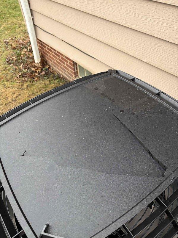 Responded to warranty service call to replace damaged weathergard top on American Standard outdoor unit. Removed cracked protective housing and installed new weathergard top cover. Inspected unit for additional damage from roof snow/ice runoff as noted on work order, documenting conditions with photos for warranty purposes.