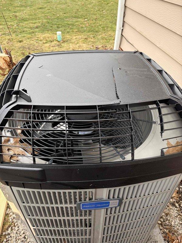 Responded to warranty service call to replace damaged weathergard top on American Standard outdoor unit. Removed cracked protective housing and installed new weathergard top cover. Inspected unit for additional damage from roof snow/ice runoff as noted on work order, documenting conditions with photos for warranty purposes.