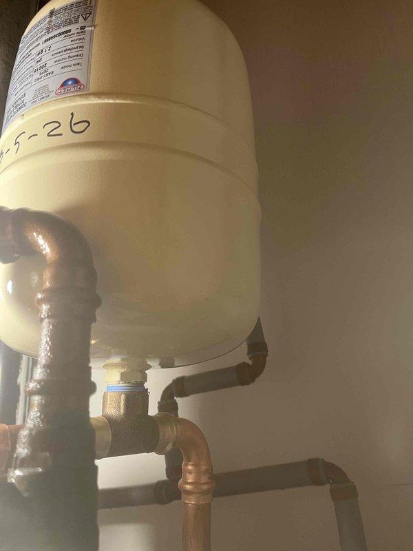 Returned to property to complete previously sold repair of jet garage floor drain. Documented existing bathroom vanity configuration and inspected expansion tank installation with connected copper supply lines. Confirmed proper operation of the floor drain system after service completion.