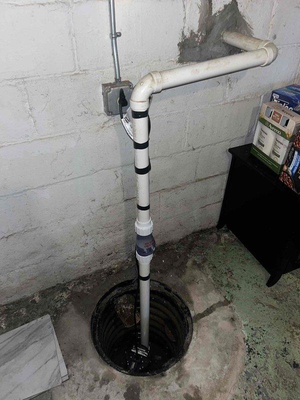 Responded to service call for non-functioning sump pump with reported burn-out issue. Upon inspection, found pump submerged in murky water with visible corrosion and mineral buildup around discharge connections. Diagnosed electrical failure in pump motor requiring replacement; customer had already disconnected power as safety precaution.