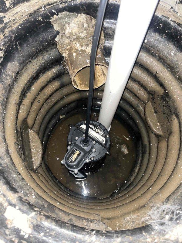 Responded to service call for non-functioning sump pump with reported burn-out issue. Upon inspection, found pump submerged in murky water with visible corrosion and mineral buildup around discharge connections. Diagnosed electrical failure in pump motor requiring replacement; customer had already disconnected power as safety precaution.