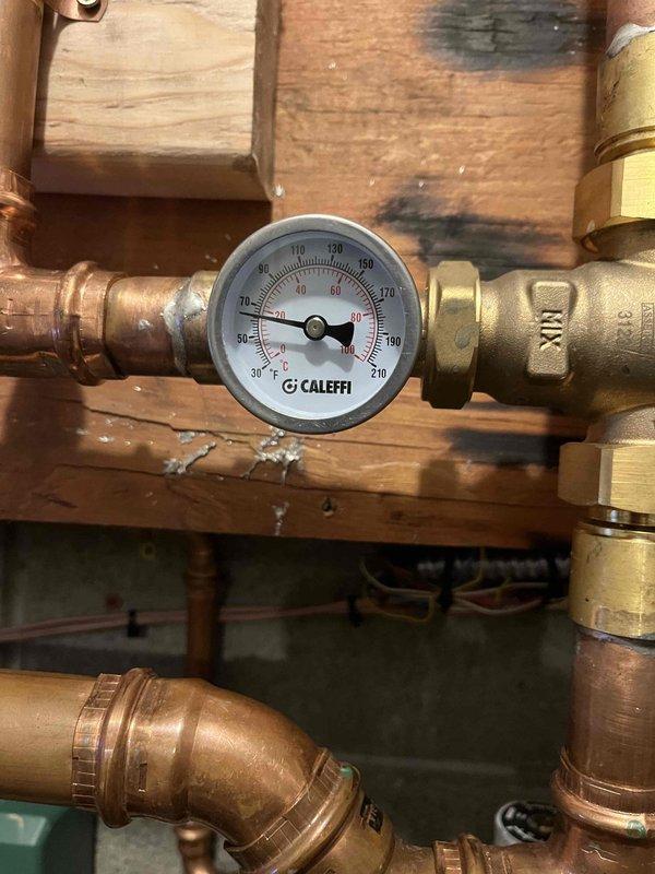 Responded to callback for recently installed Navien unit with no domestic hot water. Inspected system and identified plumbing issue rather than HVAC problem. Checked temperature gauge (reading approximately 90°F) and pressure regulator. Recommended senior plumbing technician to resolve the water supply issue affecting the unit's DHW functionality.
