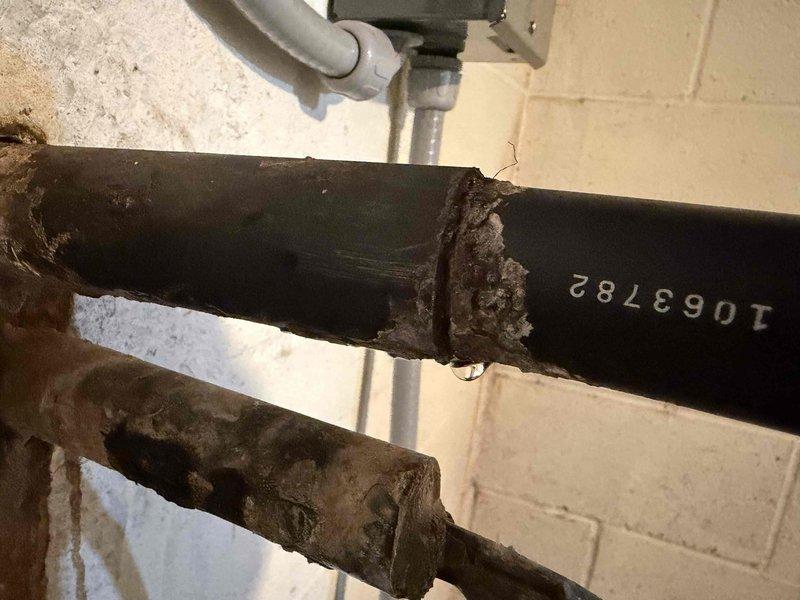 Performed heating start-up service and identified damaged insulation on black pipe (ID #1063782) with visible moisture at connection point. Inspected outdoor American Standard condenser unit which appears well-maintained with proper installation on concrete pad with stone drainage perimeter.