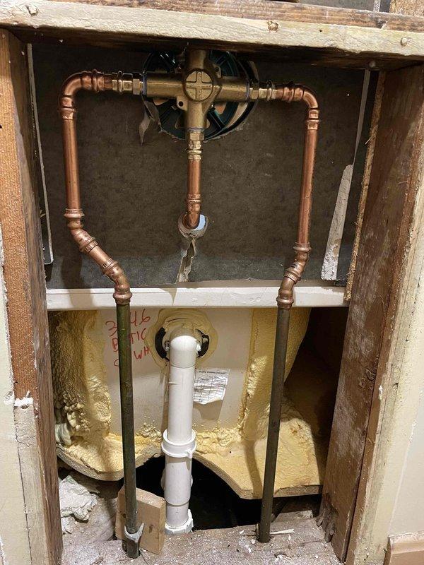 Successfully installed new shower valve and trim kit as previously sold. Completed copper pipe connections to the valve with proper fittings inside the access panel, and mounted matching chrome shower head with proper sealing. System tested with no leaks observed.