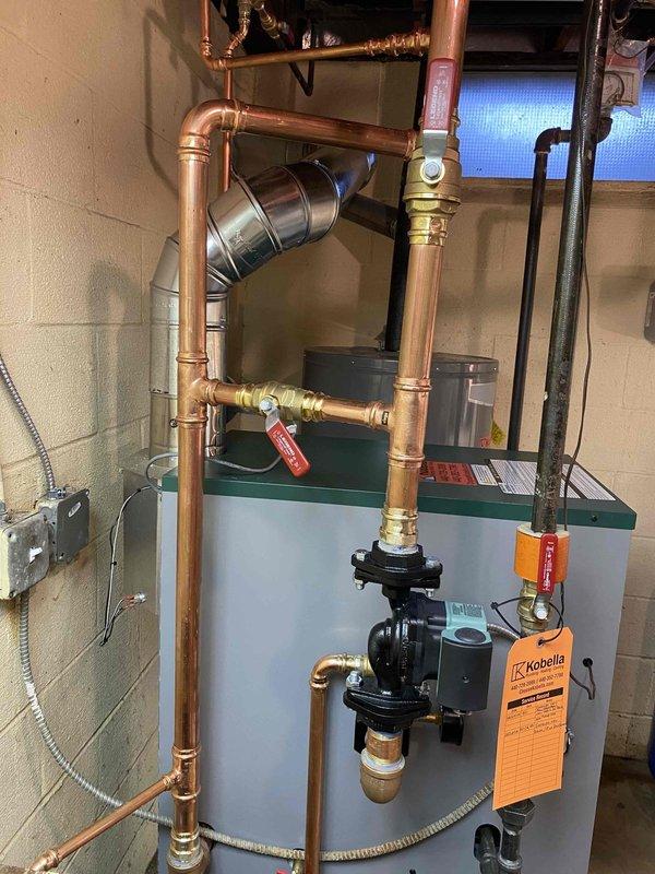 Successfully completed installation of a new boiler system with integrated circulation pump in basement utility area. Installed extensive copper piping network with appropriate valves and fittings, connecting to existing infrastructure and ventilation system. System was properly tagged, electrically connected, and photo documentation was taken of the completed installation and existing pipe configuration for service records.