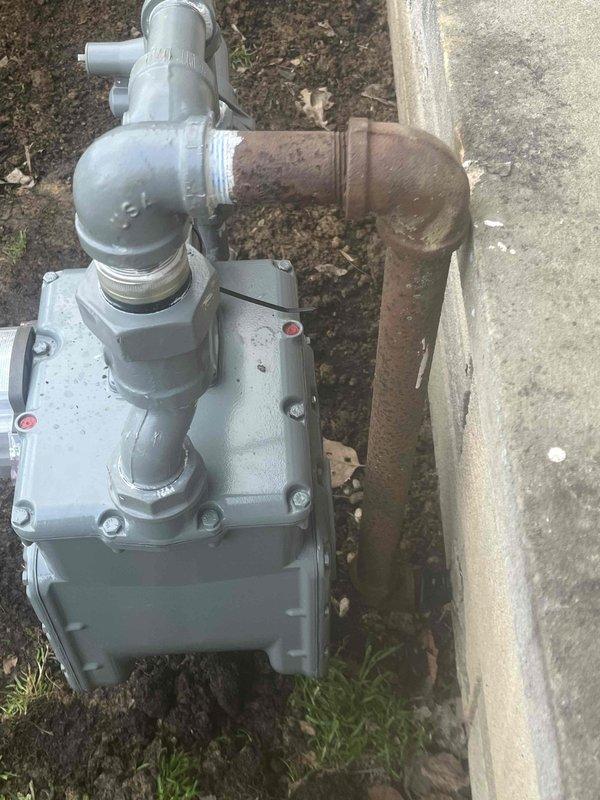 Conducted pressure test on gas line system and confirmed leak at junction where rusty iron pipe meets concrete wall. Identified significant corrosion on the main supply pipe and deterioration at connection point between newer regulator assembly and older iron pipe. Notified appropriate party of findings and recommended replacement of corroded section to restore system integrity.