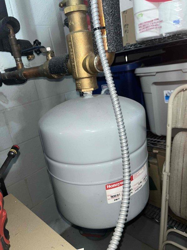 Performed routine boiler maintenance visit for club member. Inspected aging hydronic system components, noting corrosion at connection points and mineral deposits on piping. Examined Honeywell expansion tank and associated pressure relief valve, confirming proper operation of the system despite visible wear on brass components.