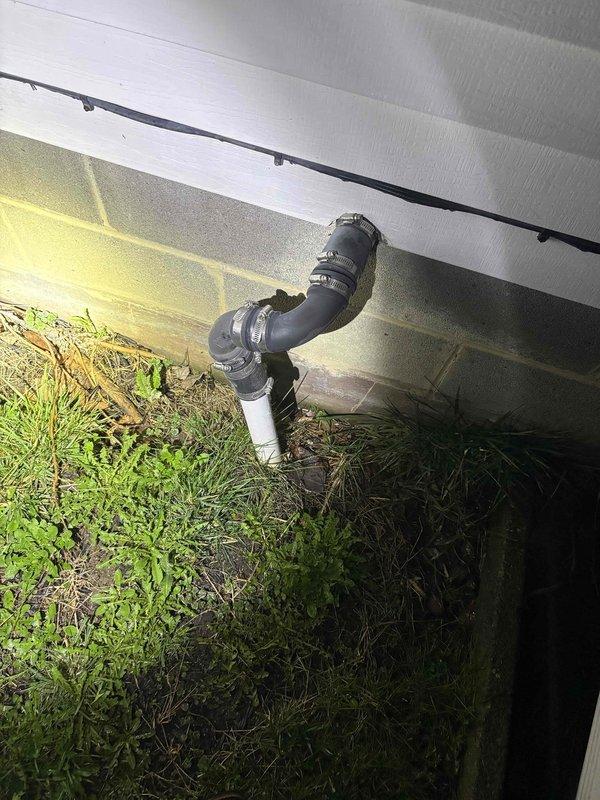 Responded to service call for sump pump alarm activation that had been occurring for approximately two weeks. Upon inspection, found the sump basin containing standing water with the pump submerged and operational. Examined exterior discharge pipe configuration and confirmed proper installation with no visible damage or blockage. Verified system functionality and addressed alarm issue.
