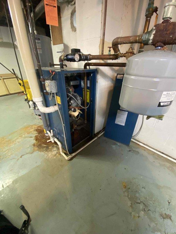Conducted assessment of existing boiler system in basement mechanical room. Inspected blue boiler unit, associated copper piping, expansion tank, and PVC ventilation components. Documented current installation configuration and noted presence of PVC drainage pipe in crawl space with proper clearances to structural elements.