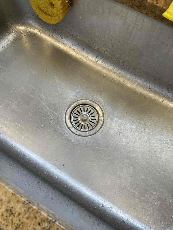 Replaced malfunctioning garbage disposal unit in stainless steel kitchen sink. Removed food debris from sink basin and drain prior to installation. Successfully installed new disposal and tested for proper operation.