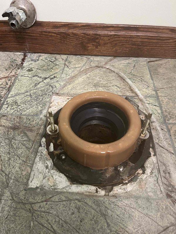 Replaced damaged wax ring on toilet flange to address leak into basement. Inspected newly installed bathroom faucet that was also contributing to the leak issue. Documented repair with photos of both the new faucet installation and the toilet flange with replacement wax ring.