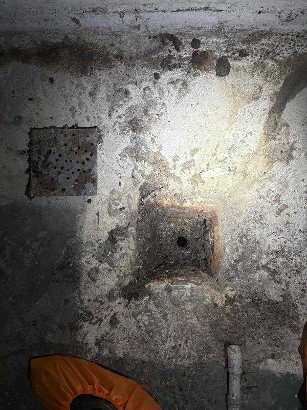 Successfully pumped out standing water from basement and attempted to clear floor drain with auger. Utilized detection equipment to identify drain location and documented significant concrete deterioration and corrosion around floor drain fixtures, which may indicate ongoing moisture issues requiring future attention.