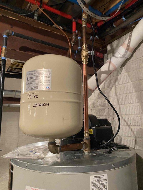 Responded to emergency service call for an 11-year-old hot water tank leak. Inspected the expansion tank which showed pressure at 75 PSI and identified this as the source of water leakage. Replaced the faulty expansion tank, tested the system for proper operation, and verified no further leaks in the plumbing network connecting to the shower fixtures.