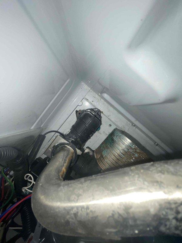 Completed service call on 4-year-old Navion combi boiler that was leaking from condensate discharge pipe (blue pipe). Identified leak source at the condensate trap connection, cleaned trap assembly and resealed connection points. Verified proper operation after repair with no further leakage observed.