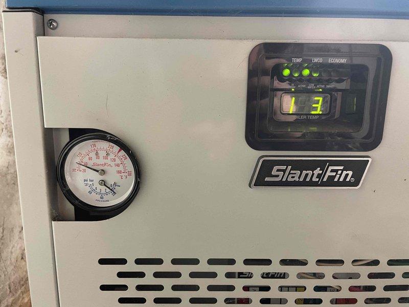 Responded to no-heat service call for Slant/Fin hot water boiler that was not providing heat or hot water. Upon inspection, discovered basement door was open causing system malfunction. Checked system diagnostics with temperature reading at 173° and pressure gauge operating within normal range, then closed door and restored normal operation of boiler for both heating and hot water functions.