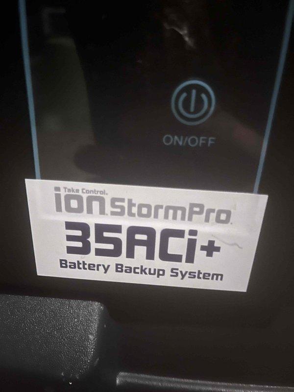 Inspected IonStormPro 35ACi+ Battery Backup System for sump pump. Diagnostic check revealed fault indicator on display panel with system showing "HELLO!" message and 0% load. Verified power connections and confirmed unit requires battery replacement to restore proper backup functionality.