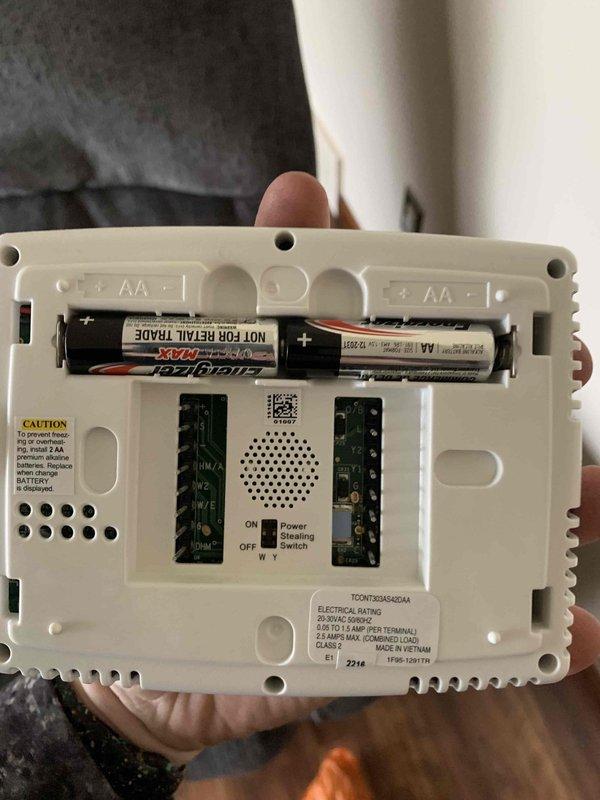 Diagnosed malfunctioning Trane thermostat displaying error code 14 with flashing red indicator light. Found unit reading 7°F despite 68°F setpoint and observed warning triangle on display. Replaced batteries and reset system to restore proper operation.