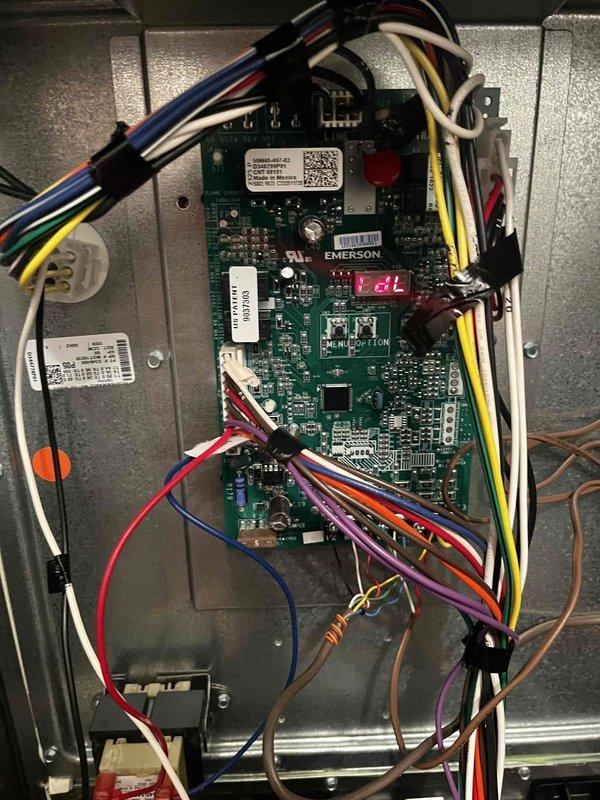 Performed routine heating maintenance on air handler unit under membership agreement. Inspected and documented motor assembly components with serial information and verified proper wire connections. Examined Emerson control board circuitry and digital display showing "E2L" code, confirming all wiring harnesses were secure and properly connected.
