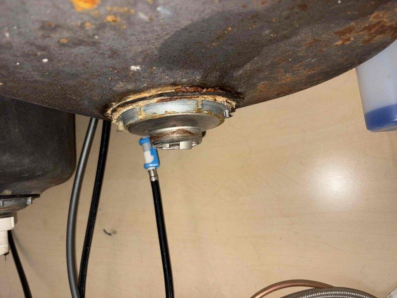 Repaired leaking sink drain by updating tubular components to match existing fixtures and ensure proper drainage. Raised the Air Admittance Valve (AAV) to comply with current plumbing code requirements. Lowered the 90-degree elbow under kitchen sink to establish correct drain pitch, eliminating previous water damage issues evident from cabinet staining.