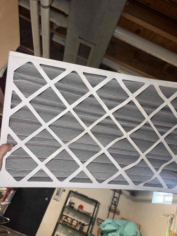 Responded to no heat call for furnace system blowing cold air. Inspected air filter and found it to be excessively clogged, restricting proper airflow. Replaced filter with new one, restoring normal system operation and resolving the heating issue.