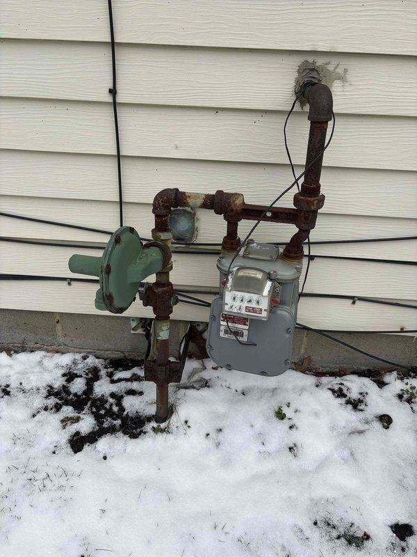 Conducted site assessment for new gas line installation to service pool heater. Observed existing meter setup with significant corrosion on iron pipes and connections. Need to confirm pool heater BTU requirements to properly size the new gas line and determine if system requires pounds configuration based on load requirements.