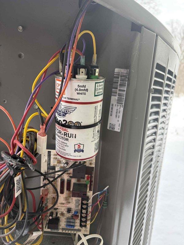Diagnosed heat pump system showing "heat on" flashing indicator before power loss. Inspection revealed faulty capacitor (5mfd 440VAC) with visible discoloration affecting the air handler operation. Replaced capacitor, restoring proper system function and resolving the no-heat condition.