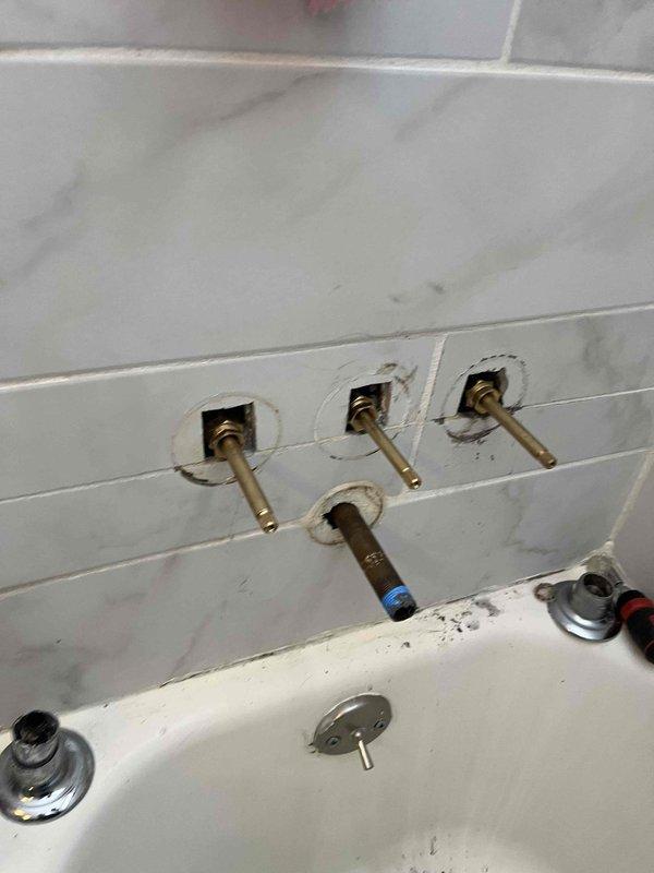 Replaced worn faucet stems and drain diverter in bathtub shower to address leaking knobs. System pressure testing confirmed proper operation at approximately 90-100 PSI after installation.
