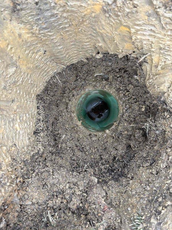 Successfully cleared a drain line using snake and jetting methods to remove debris and sediment. Visual inspection of the AH drain pipe revealed standing water with visible sediment accumulation and mineral buildup along interior walls, confirming effective restoration of proper drainage function.
