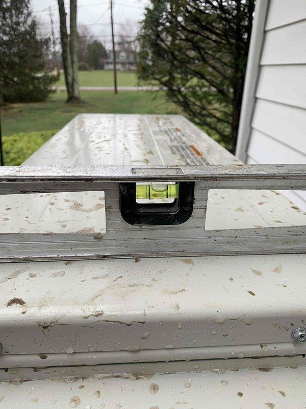 Successfully completed installation preparation for complete HVAC system. Verified and confirmed proper leveling of the outdoor condensing unit using a spirit level. Awaiting customer to remove bushes on side of home to finalize outdoor unit placement.