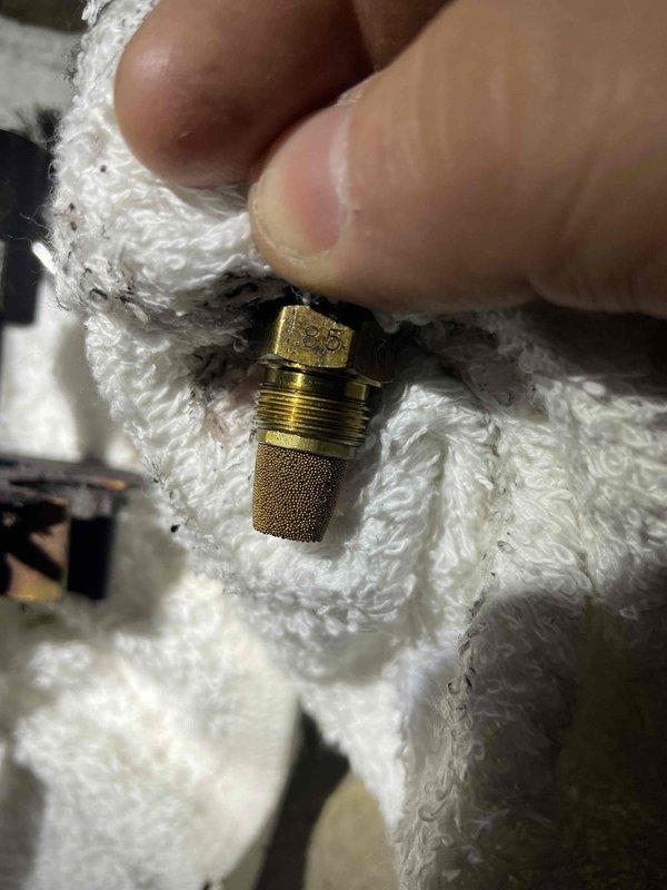 Responded to no heat call for oil furnace. Inspected and removed fuel nozzle assembly, finding clogged screen/filter which was restricting proper fuel atomization. Cleaned and replaced nozzle to restore proper heating function.